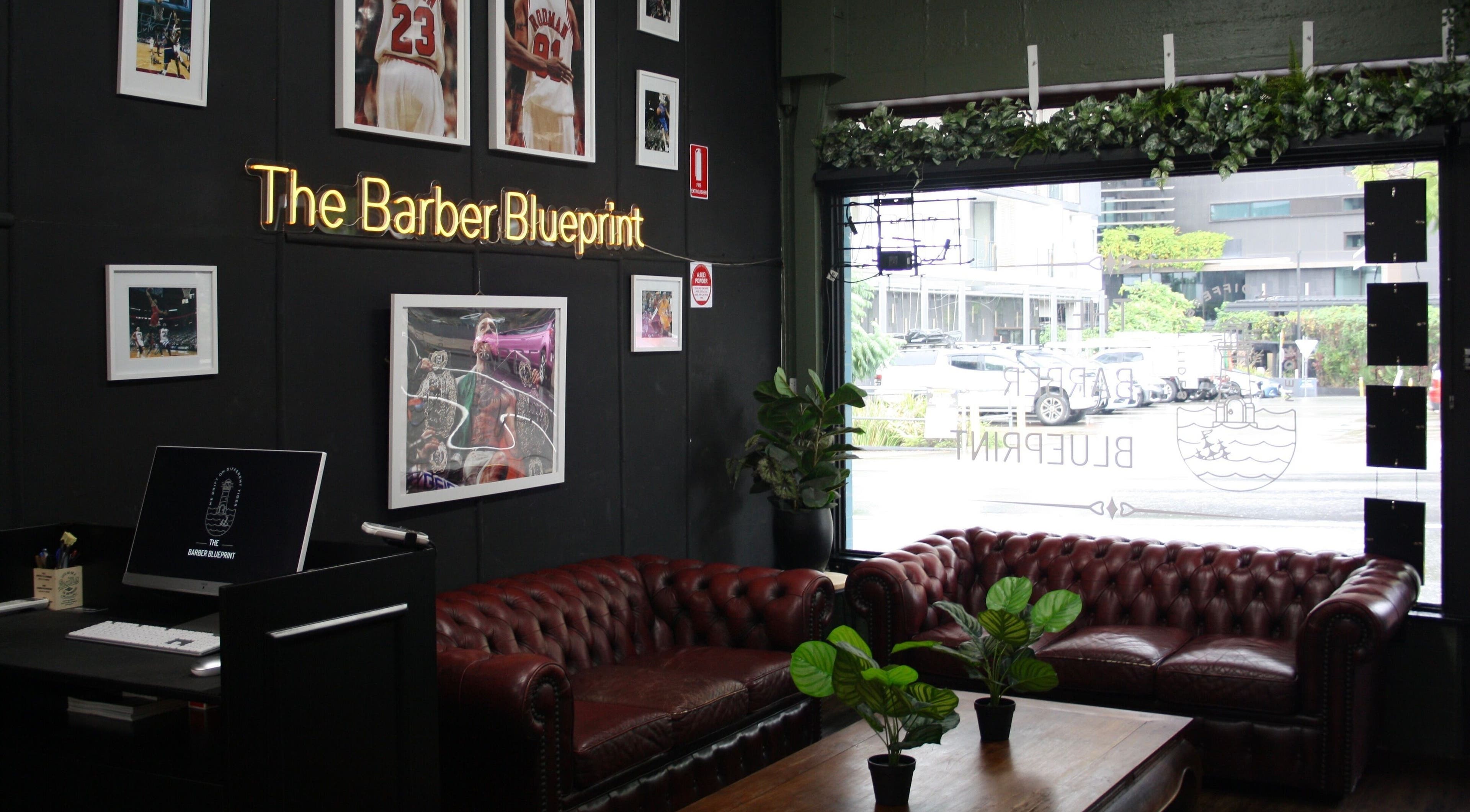 Elegant lounge area at The Barber Blueprint, Nundah, Queensland, AU, featuring leather sofas and stylish decor.