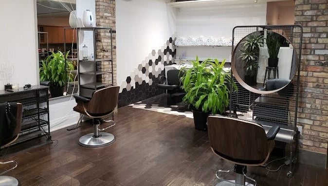 Modern interior of [Sekt] Hair Studio in Toronto with lush plants and stylish chairs.