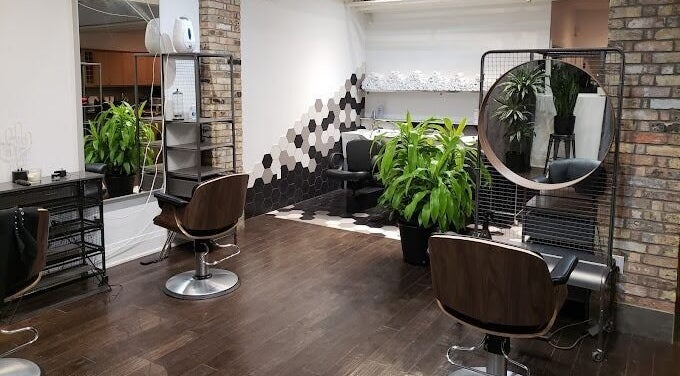 Modern interior of [Sekt] Hair Studio in Toronto with lush plants and stylish chairs.