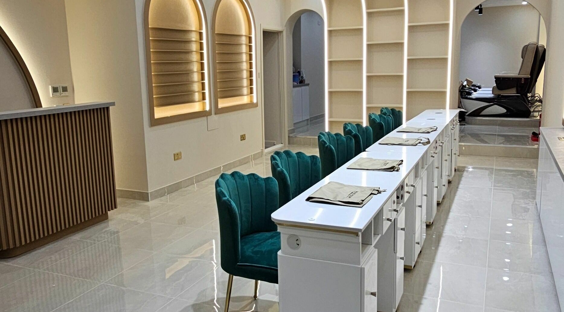 Elegant interior of The Nail Polish Bromley, featuring plush teal chairs and sleek nail stations in Bromley, England, GB.