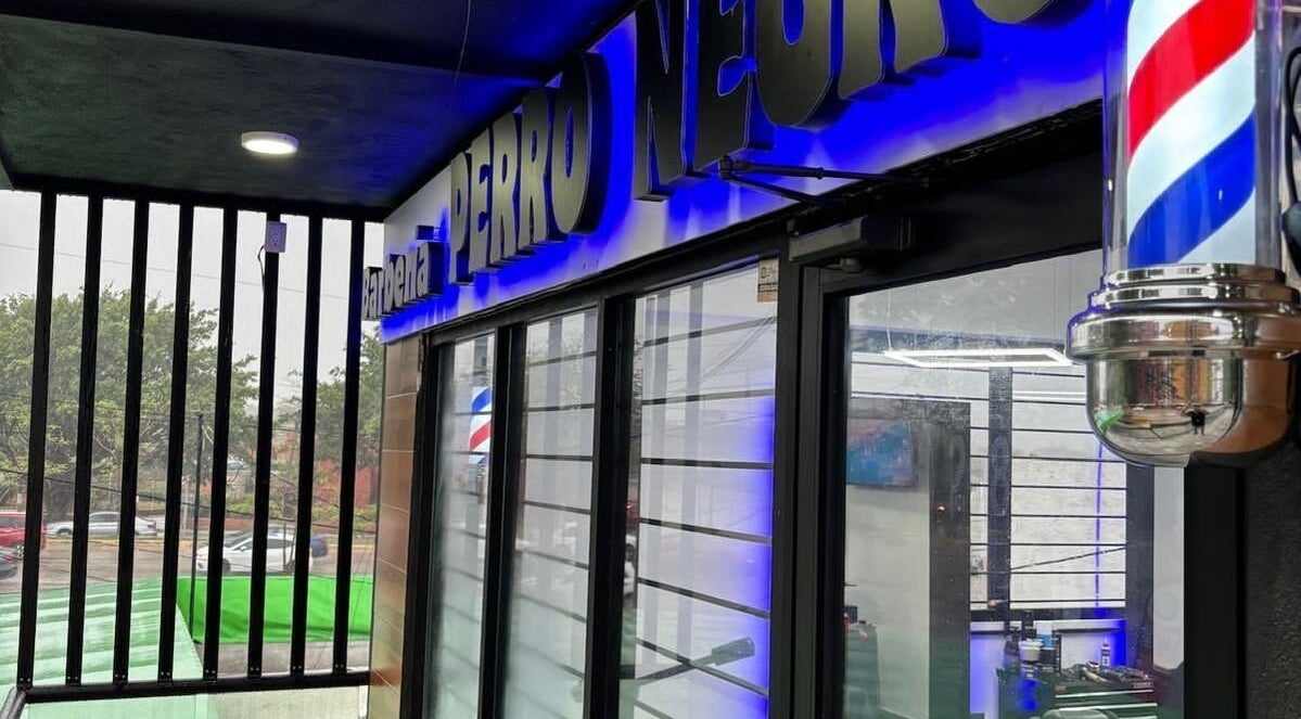 Fachada de Barbería PERRO NEGRO en Villahermosa, Tabasco, MX con iluminación azul llamativa.