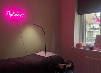Cozy treatment room at Lashes by Eden in Brighton And Hove, England, GB featuring pink neon sign.