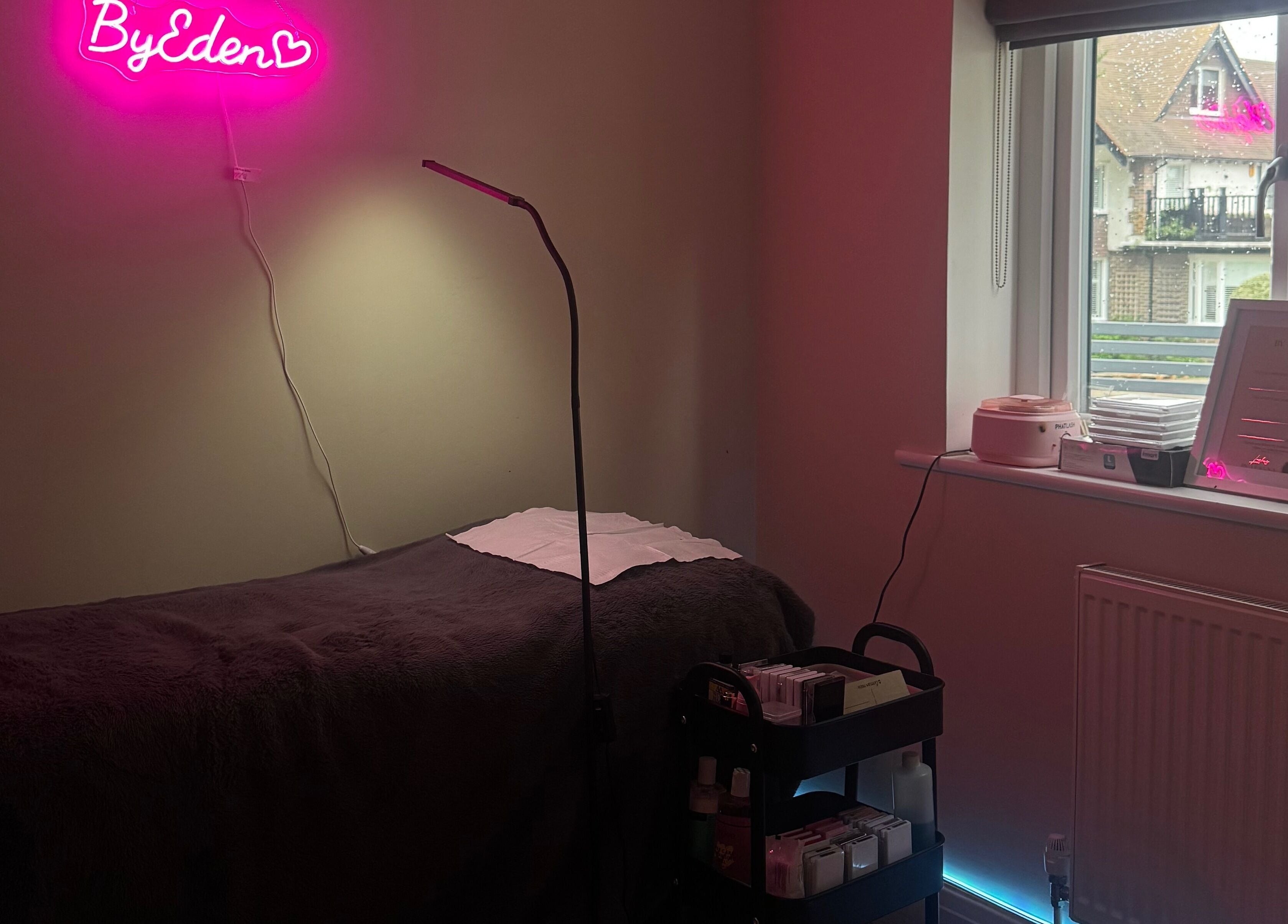 Cozy treatment room at Lashes by Eden, Brighton And Hove, England, featuring a plush bed and modern decor.