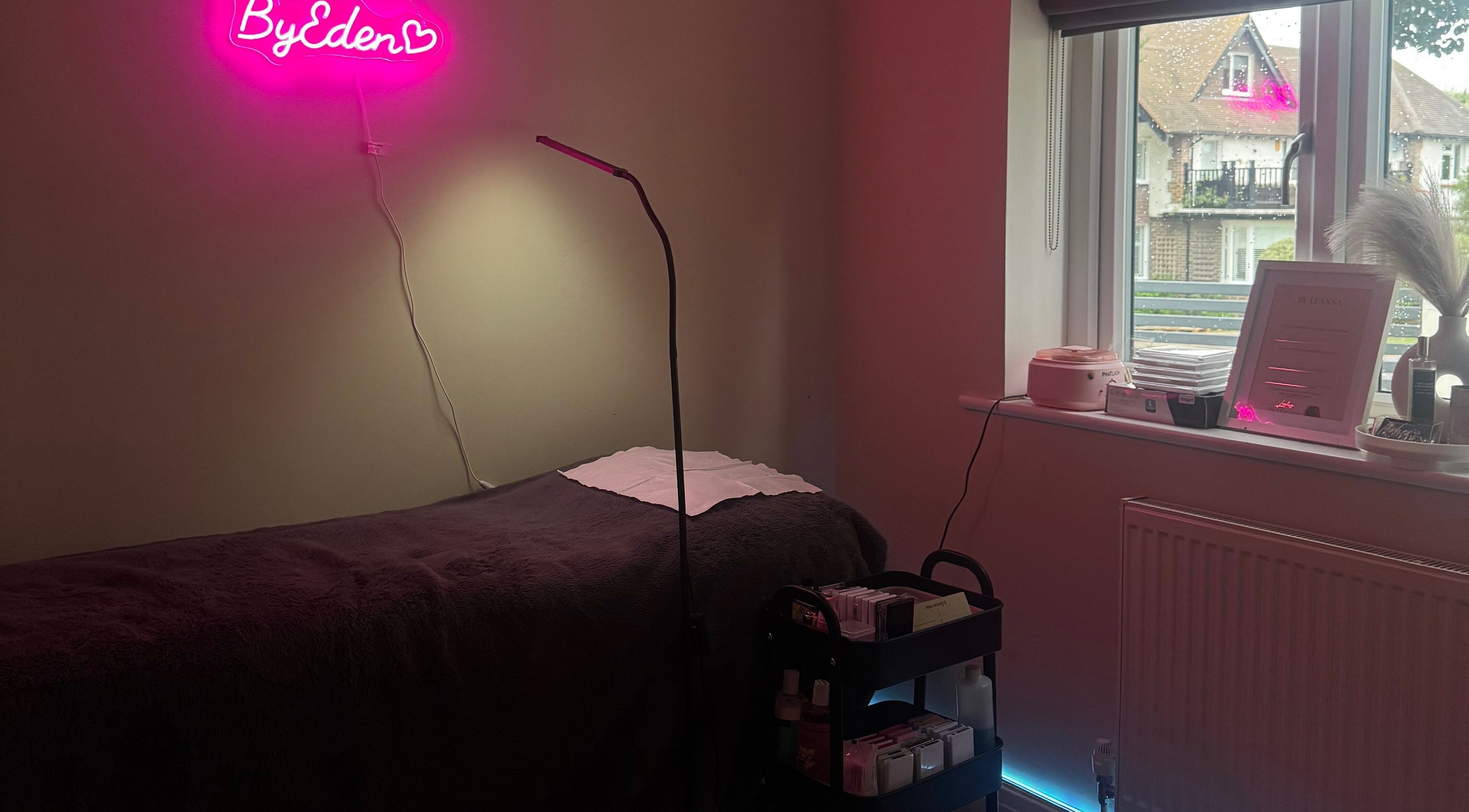 Cozy treatment room at Lashes by Eden, Brighton And Hove, England, featuring a plush bed and modern decor.