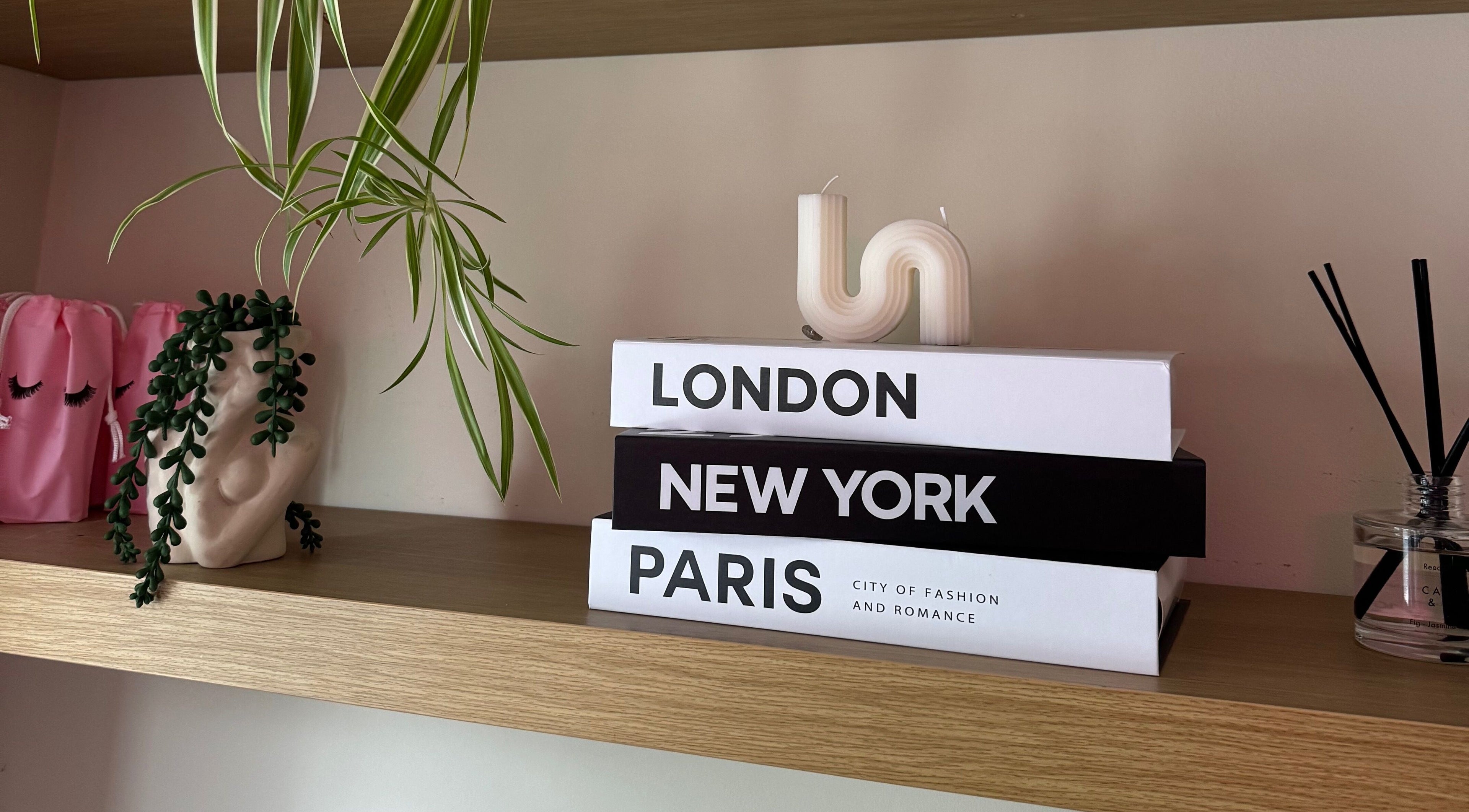 Styled wooden shelf at Lashes by Eden, Brighton And Hove, England, GB, with books, plant, and candle.
