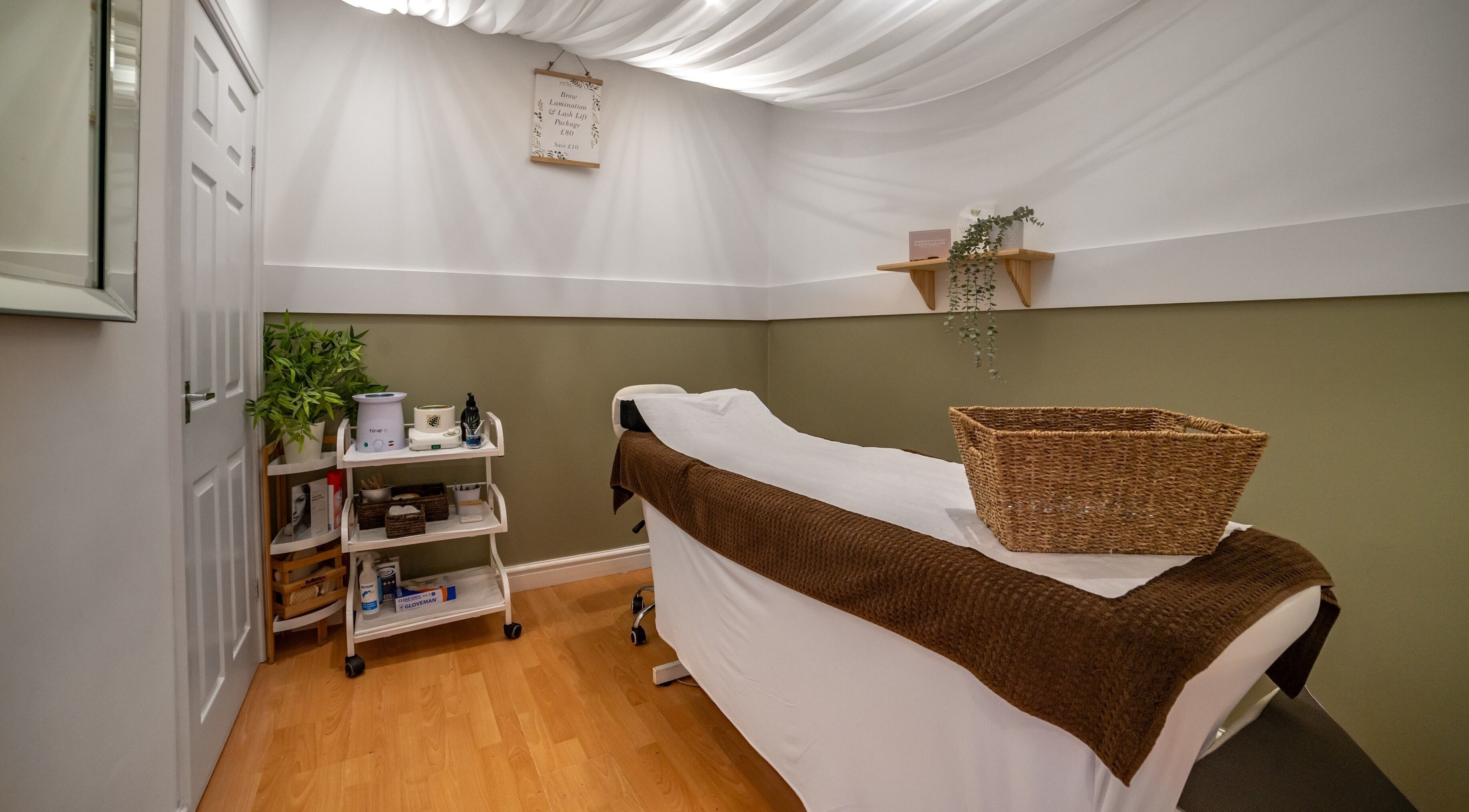 Cozy treatment room at Bare Beauty, Altrincham, England, GB, featuring a massage bed and soothing decor.