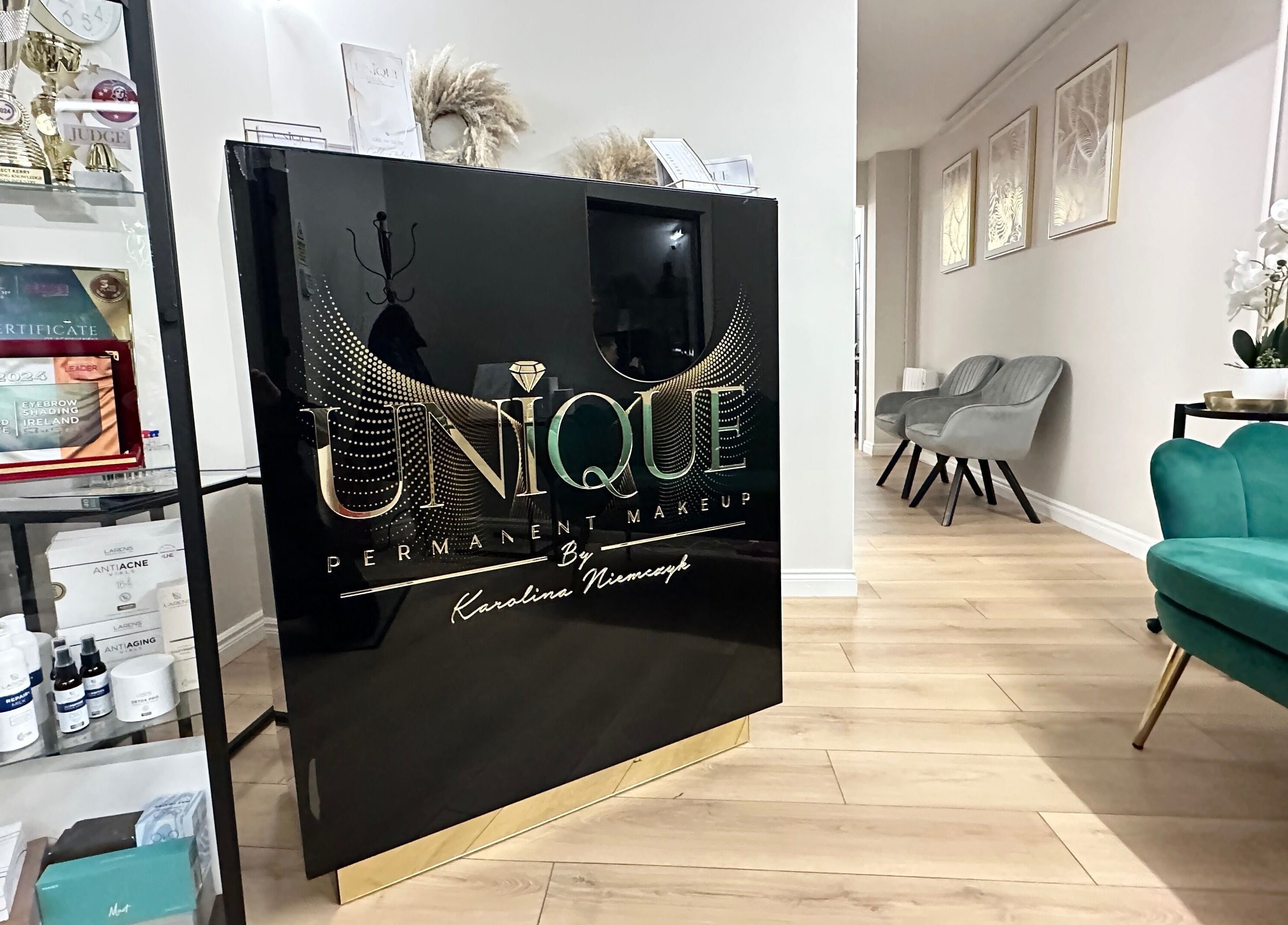 Reception area at Unique Permanent Makeup, Tralee, County Kerry, IE featuring sleek decor and award display.