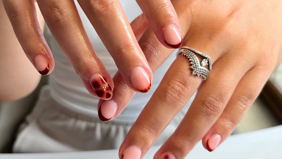 Elegant nail art with red accents at The Biab Room, Cwmparc, Wales, GB.