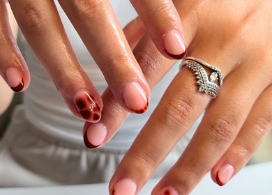 Elegant nail art with red accents at The Biab Room, Cwmparc, Wales, GB.