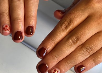 Burgundy nail art with floral accent at The Biab Room, Cwmparc, Wales, GB.