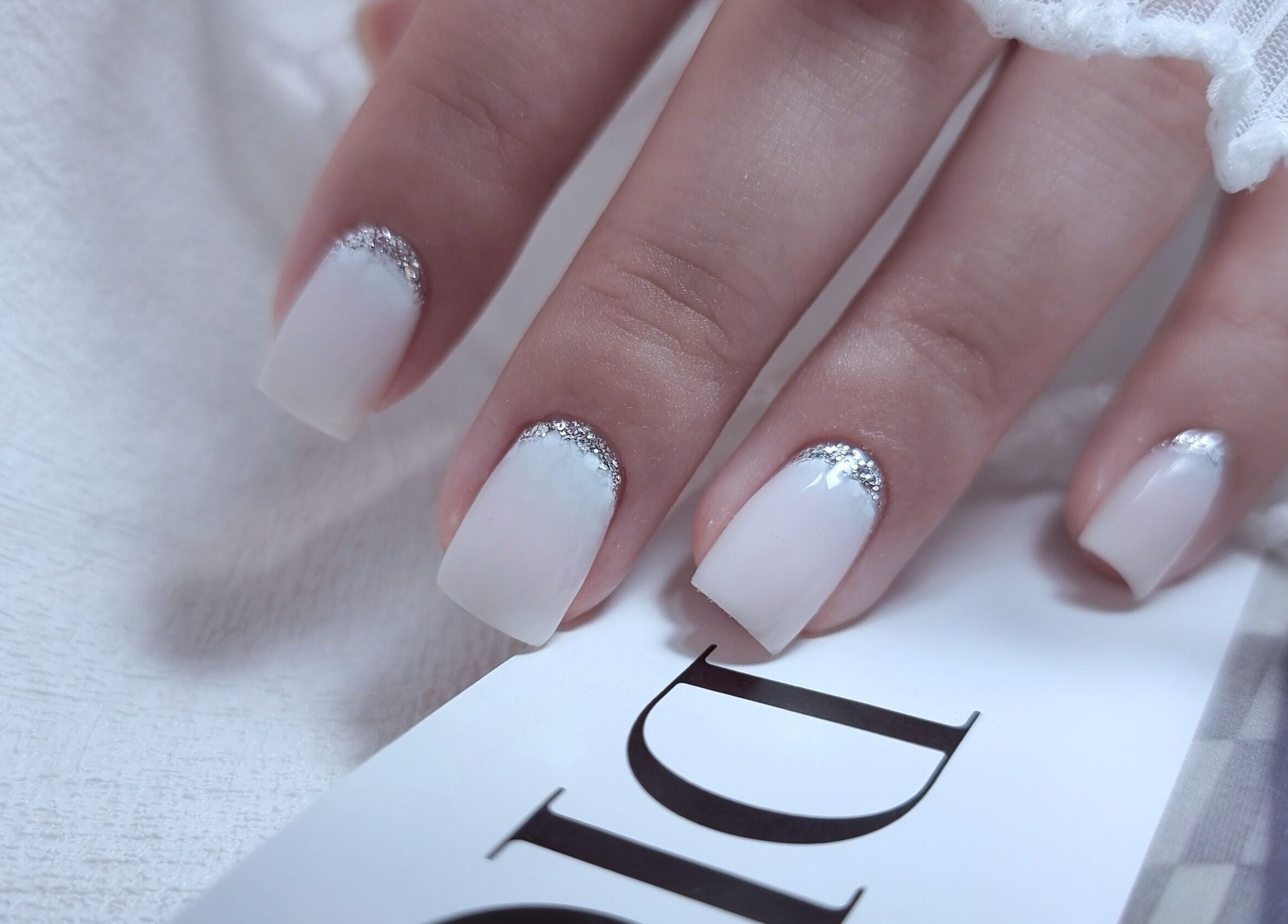 Chic white nails with silver tips at Zhekova Nails Academy, Epsom, England, GB, showcasing modern elegance.