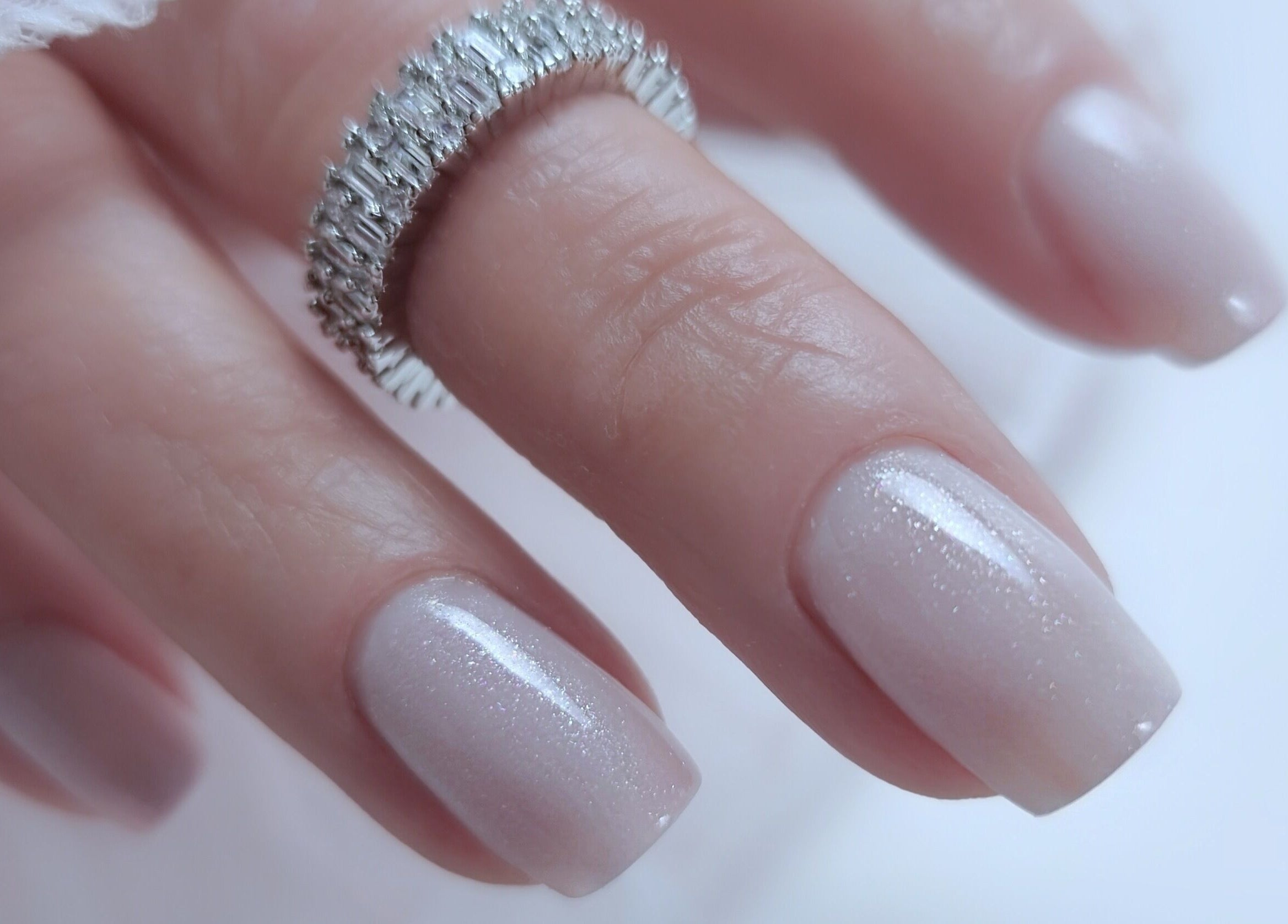 Elegant manicured nails with a sparkling ring at Zhekova Nails Academy, Epsom, England, GB.
