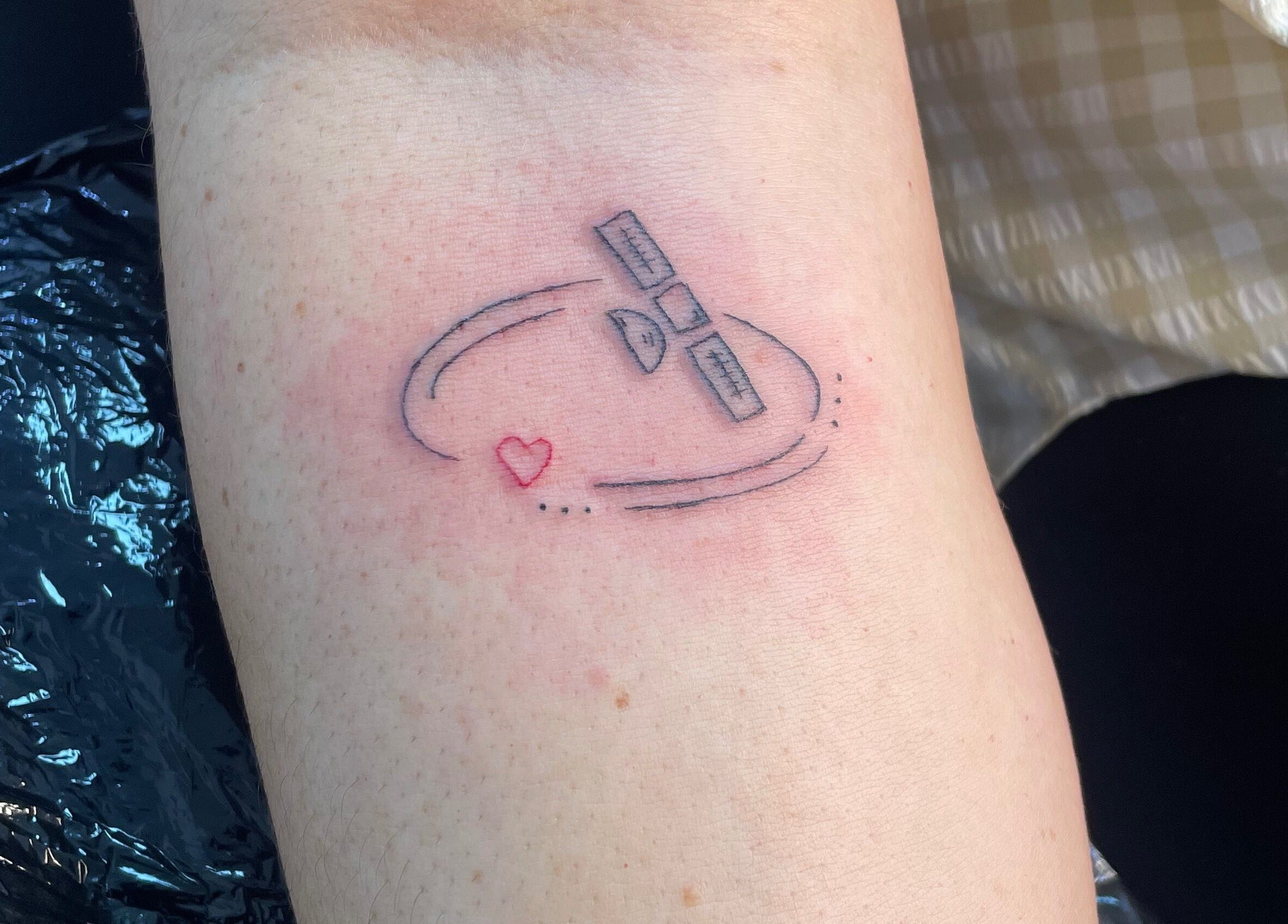 Minimalist satellite and heart tattoo at Adara Ink, Chadderton, England, GB. Unique body art design.