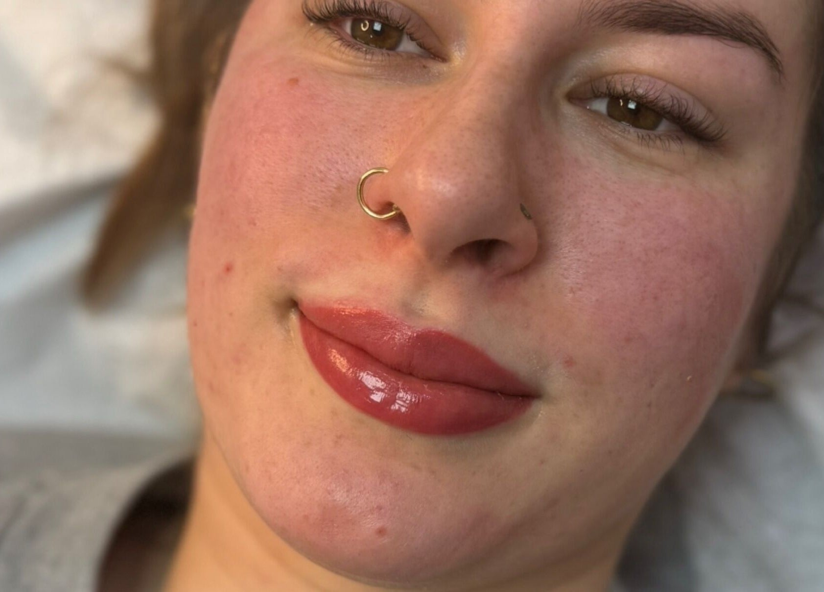 Close-up of a woman's glowing skin and lips after treatment at Adara Ink, Chadderton, England, GB.