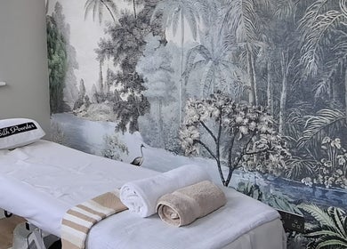 Tranquil spa room at Silk Powder Limited, Leicestershire, GB, featuring massage table and soothing mural.
