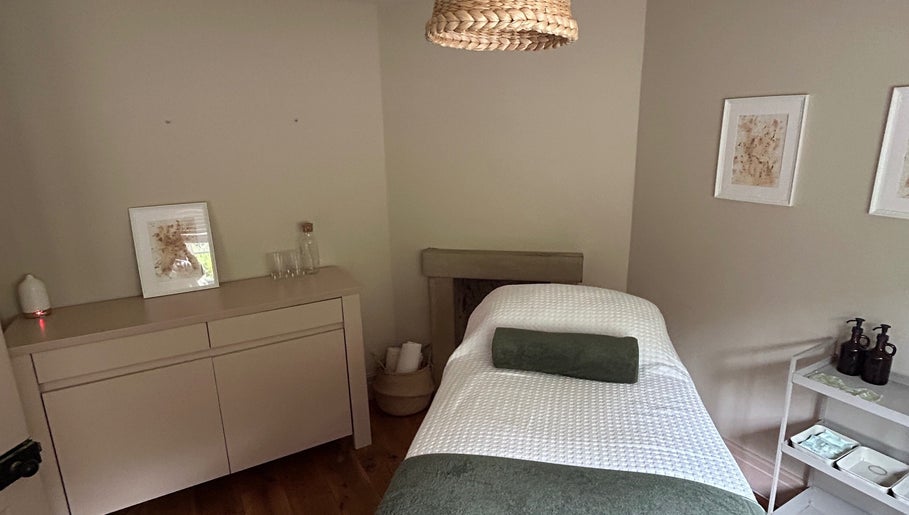 Serene therapy room at LH Therapies in North Rigton, England featuring a cozy massage table and calming decor.
