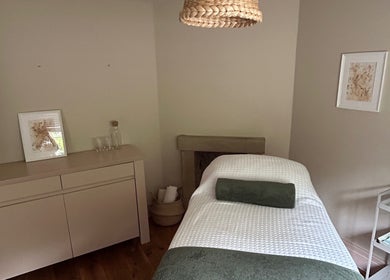 Serene therapy room at LH Therapies in North Rigton, England featuring a cozy massage table and calming decor.