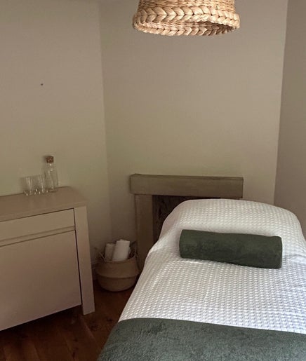 Serene therapy room at LH Therapies in North Rigton, England featuring a cozy massage table and calming decor.