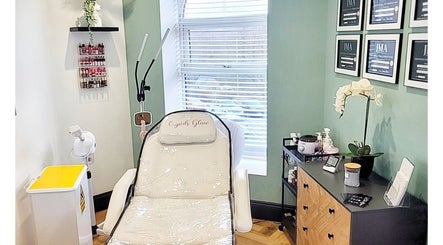Elegant treatment room at Cupids Glow, Bolton, England, GB with a plush chair, certificates, and skincare products.