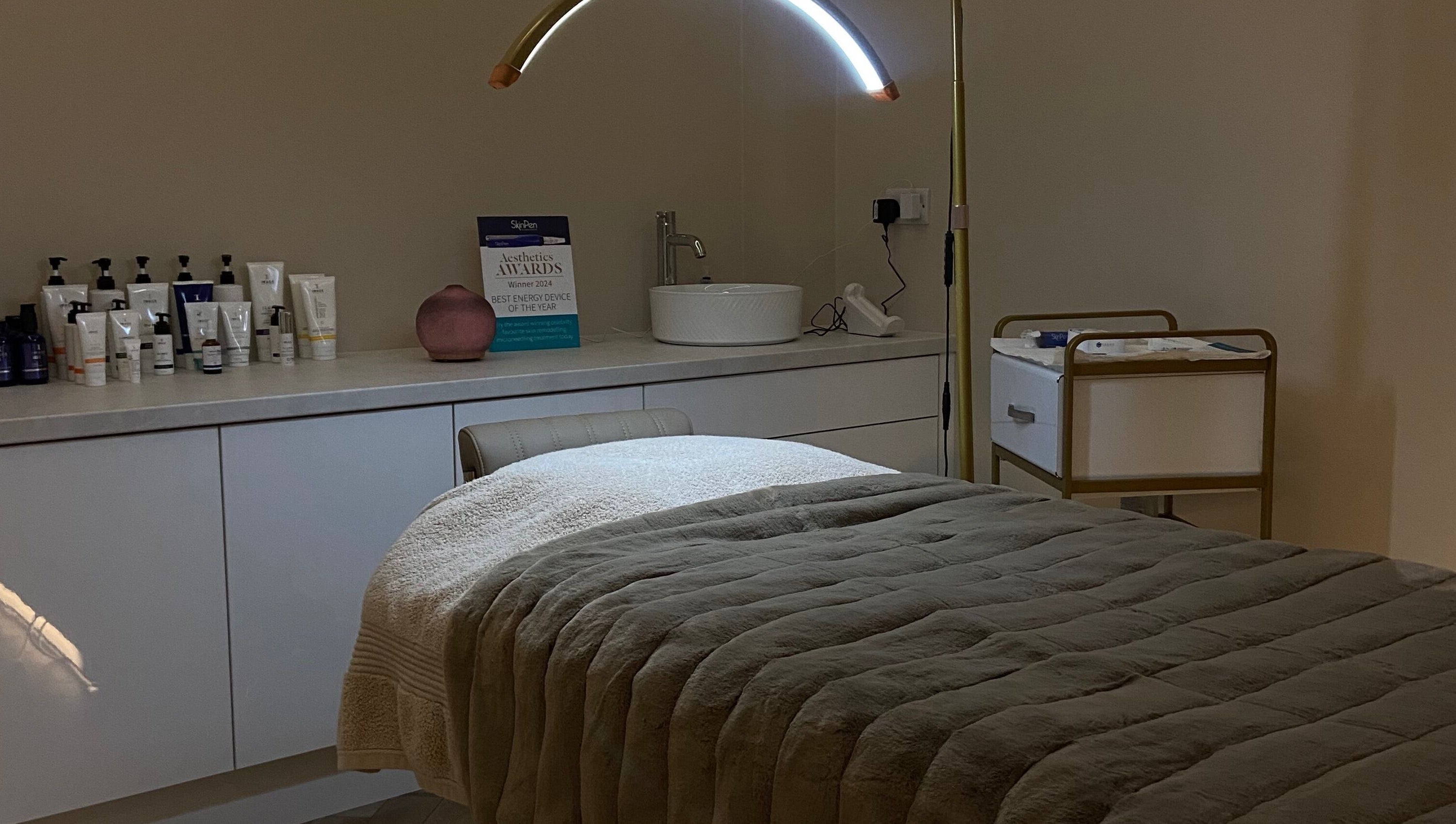 A cozy treatment room at Studio 3, Swatragh, Northern Ireland, GB featuring a plush bed and skincare products.