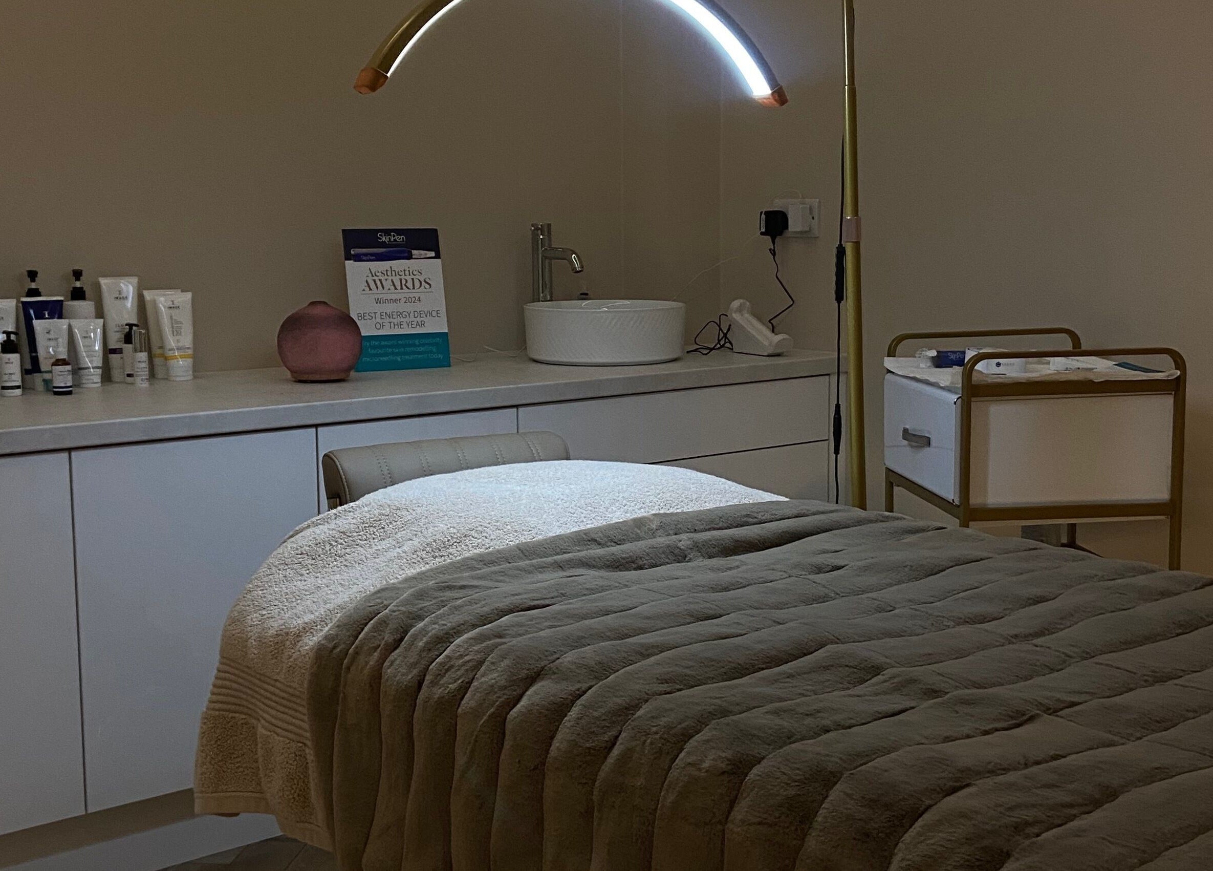 A cozy treatment room at Studio 3, Swatragh, Northern Ireland, GB featuring a plush bed and skincare products.