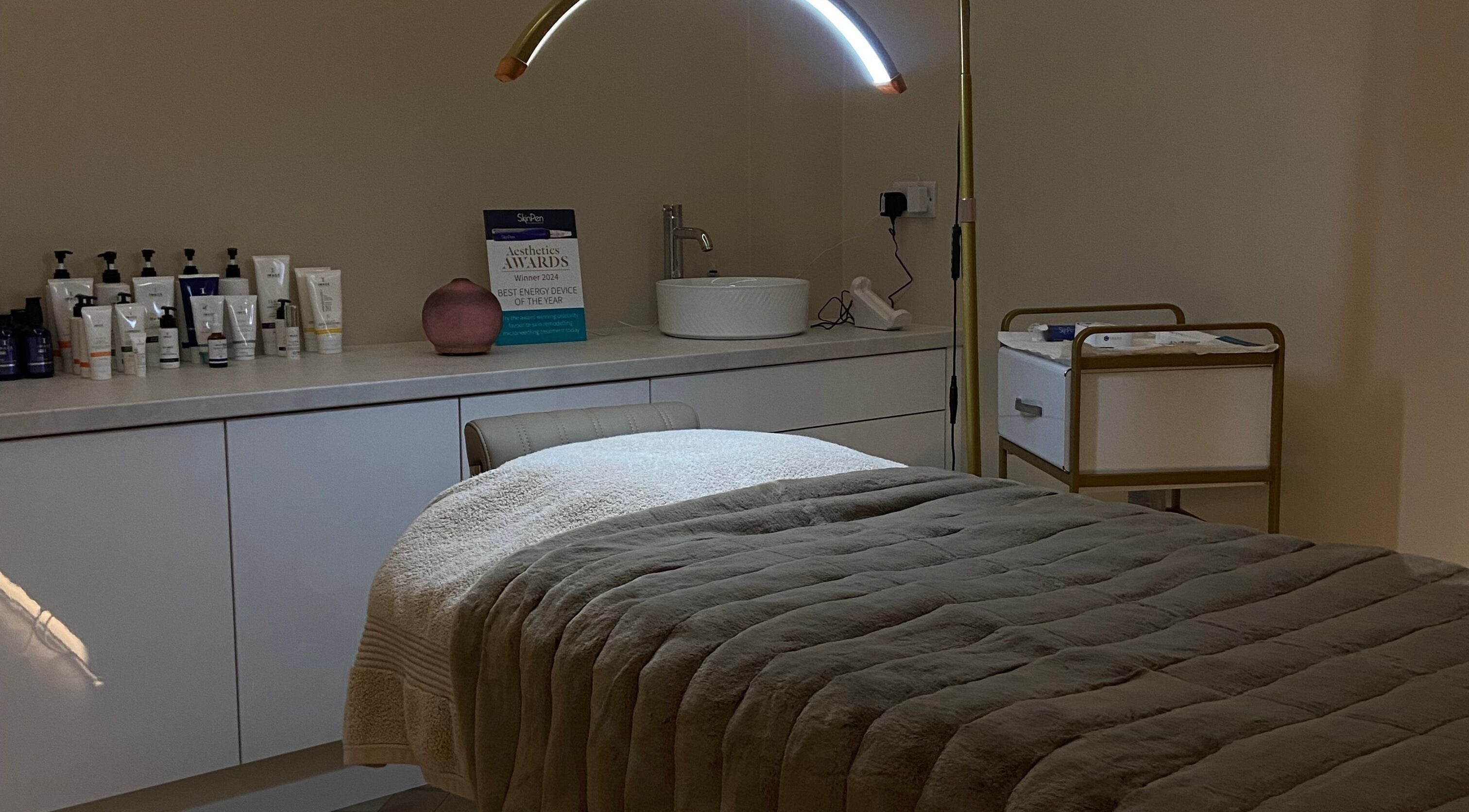 A cozy treatment room at Studio 3, Swatragh, Northern Ireland, GB featuring a plush bed and skincare products.