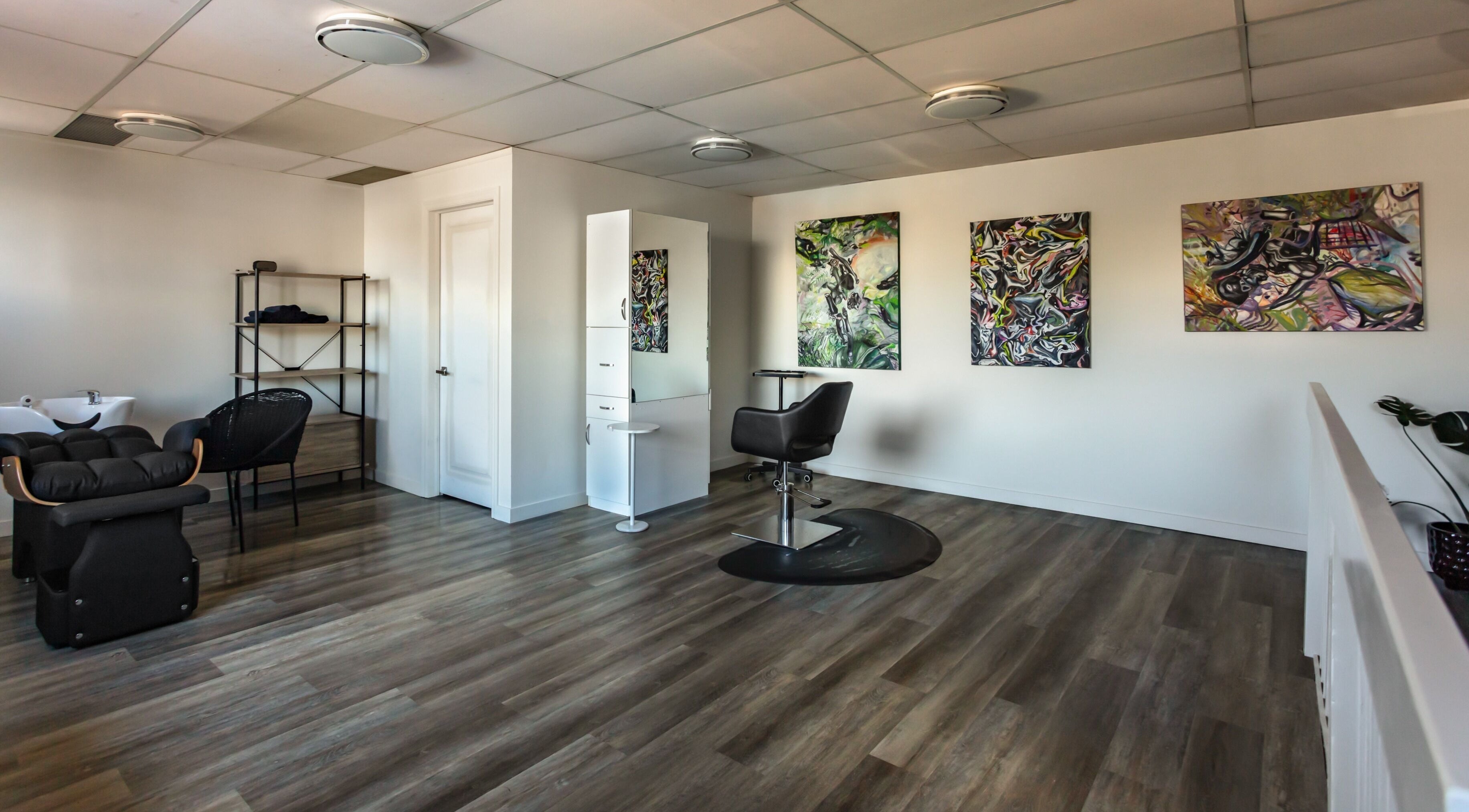 Spacious interior of Mirror Mirror Hair Studio in Oshawa, Ontario, CA, featuring stylish decor and modern chairs.