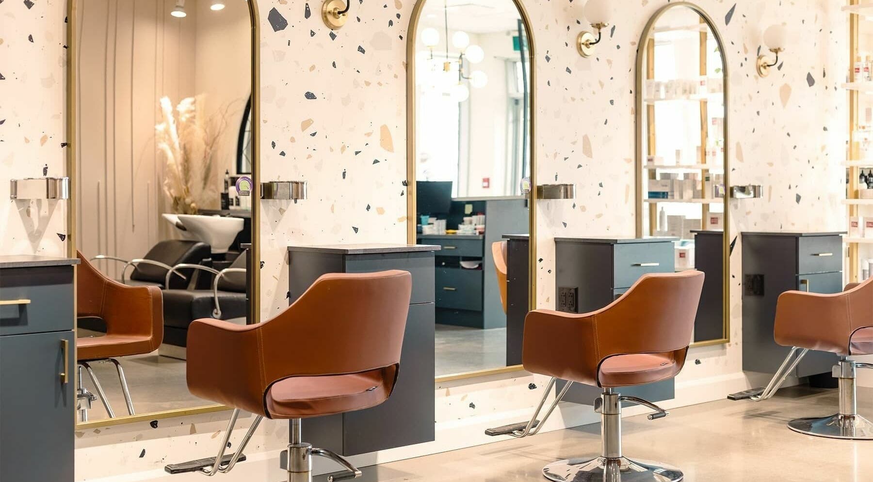 Intérieur élégant de Le Vermeil à Saint-bruno-de-montarville, avec des fauteuils de salon modernes et miroirs.