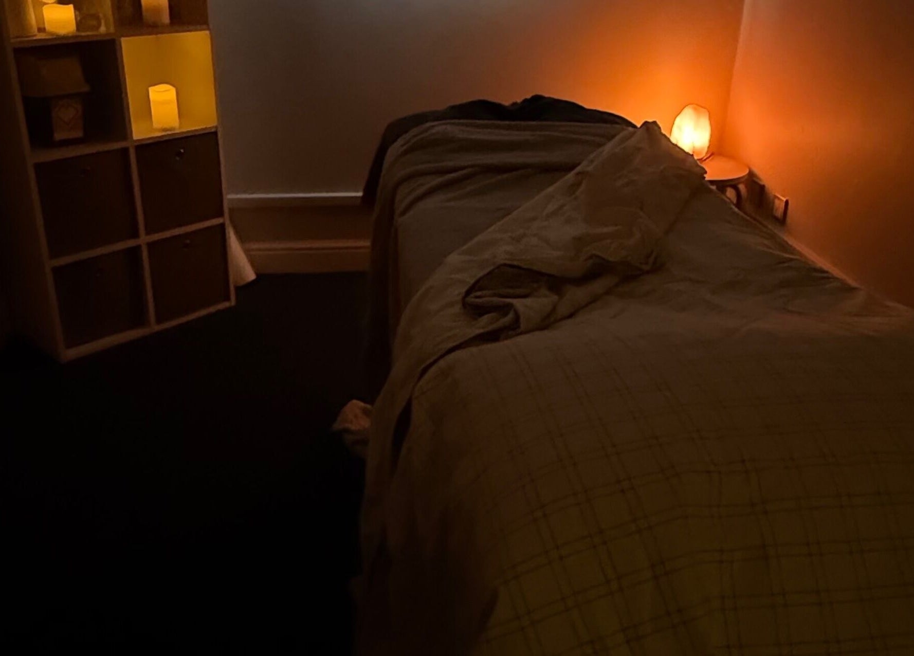 Tranquil massage room at MASSAGE BY ZOE in Corby, England, GB with warm lighting and a comfortable bed.