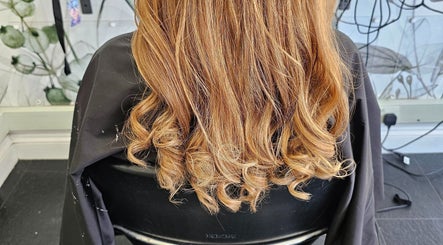 Beautiful golden curls styled at Hair By Tory in Stowmarket, England, GB salon chair.
