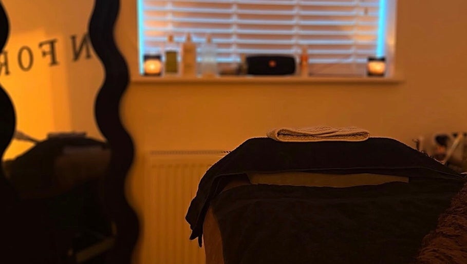 Peaceful treatment room at SKNFORM in Newton-le-willows, England, GB, with candles and dim lighting.