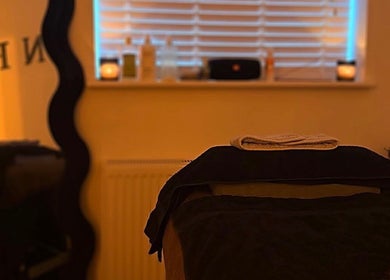 Peaceful treatment room at SKNFORM in Newton-le-willows, England, GB, with candles and dim lighting.