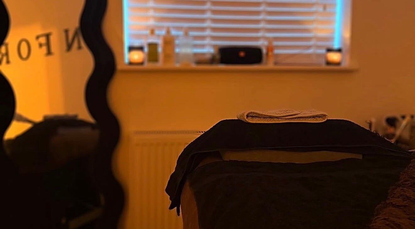 SKNFORM massage room with soft lighting in Newton-le-willows, England, GB, featuring a prepared therapy bed.