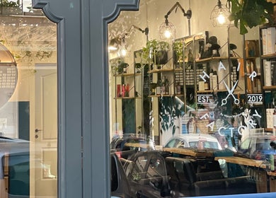 Vetrina di Hair Factory a Roma, Lazio, IT, con prodotti per capelli esposti e riflesso di auto.