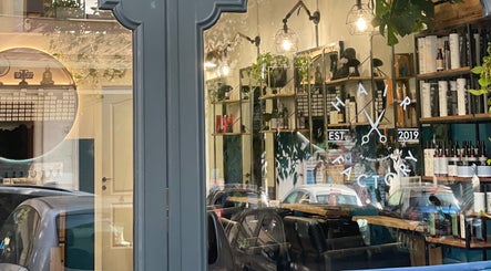 Vetrina di Hair Factory a Roma, Lazio, IT, con prodotti per capelli esposti e riflesso di auto.