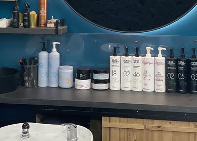 Prodotti per capelli nel salone Hair Factory a Roma, Lazio, IT, su lavandino moderno e ripiani eleganti.