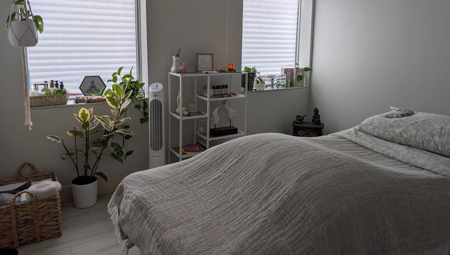 Tranquil massage room at The Celestial Root in Belleville, Ontario, CA with cozy bed and serene decor.