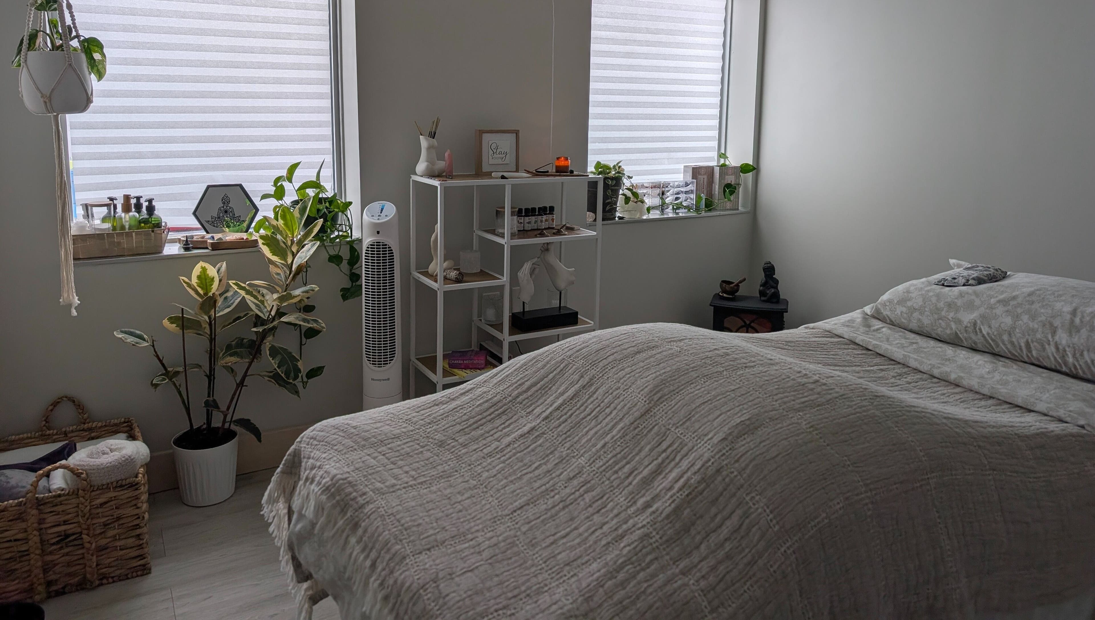 Tranquil massage room at The Celestial Root in Belleville, Ontario, CA with cozy bed and serene decor.