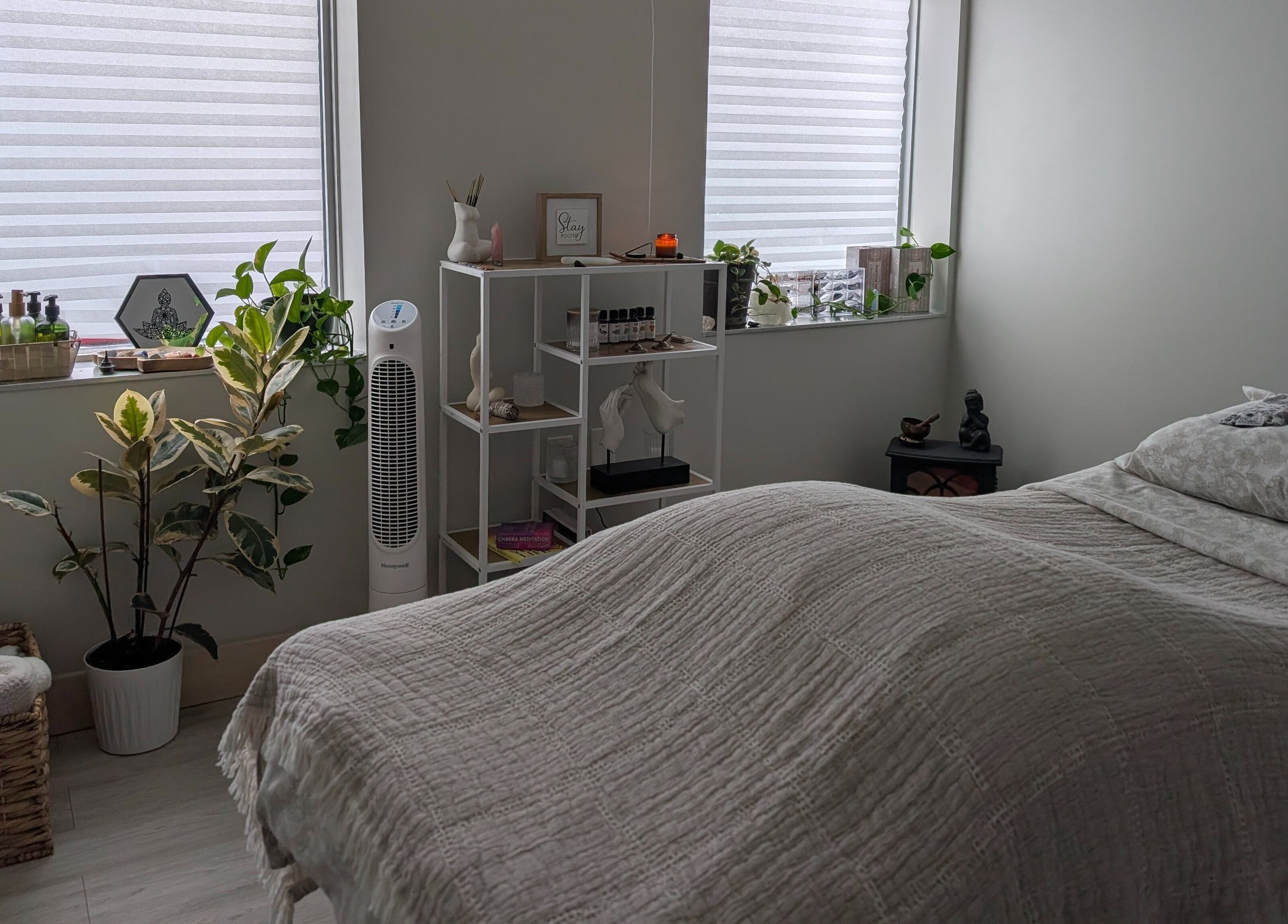 Tranquil massage room at The Celestial Root in Belleville, Ontario, CA with cozy bed and serene decor.