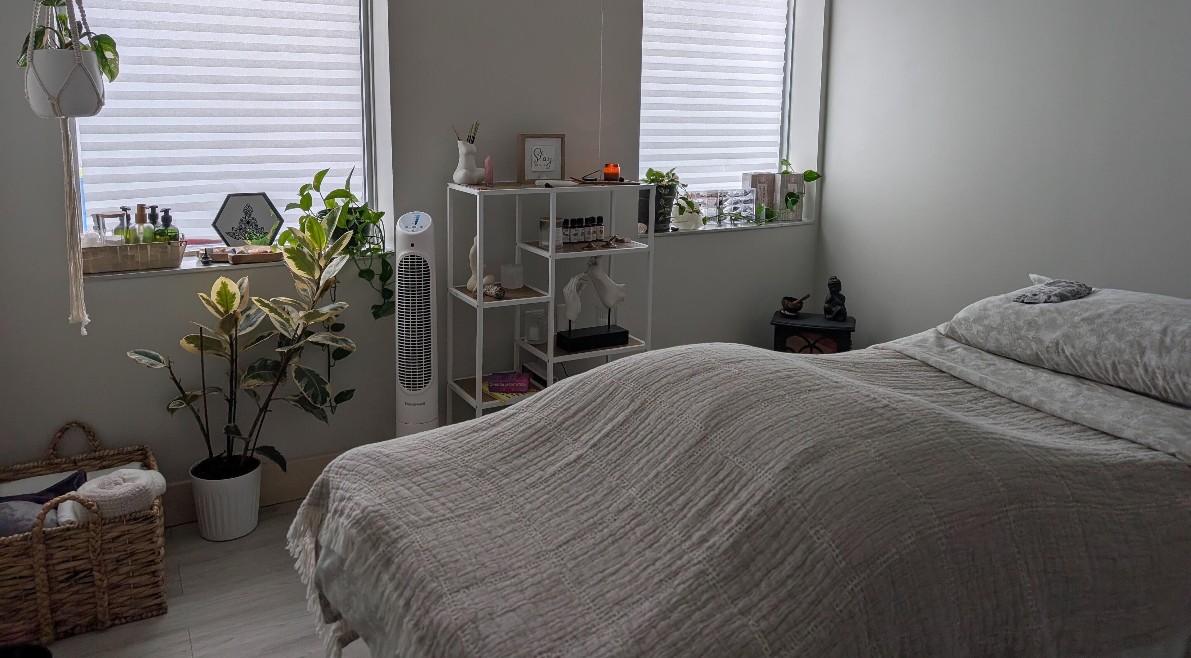 Tranquil massage room at The Celestial Root in Belleville, Ontario, CA with cozy bed and serene decor.
