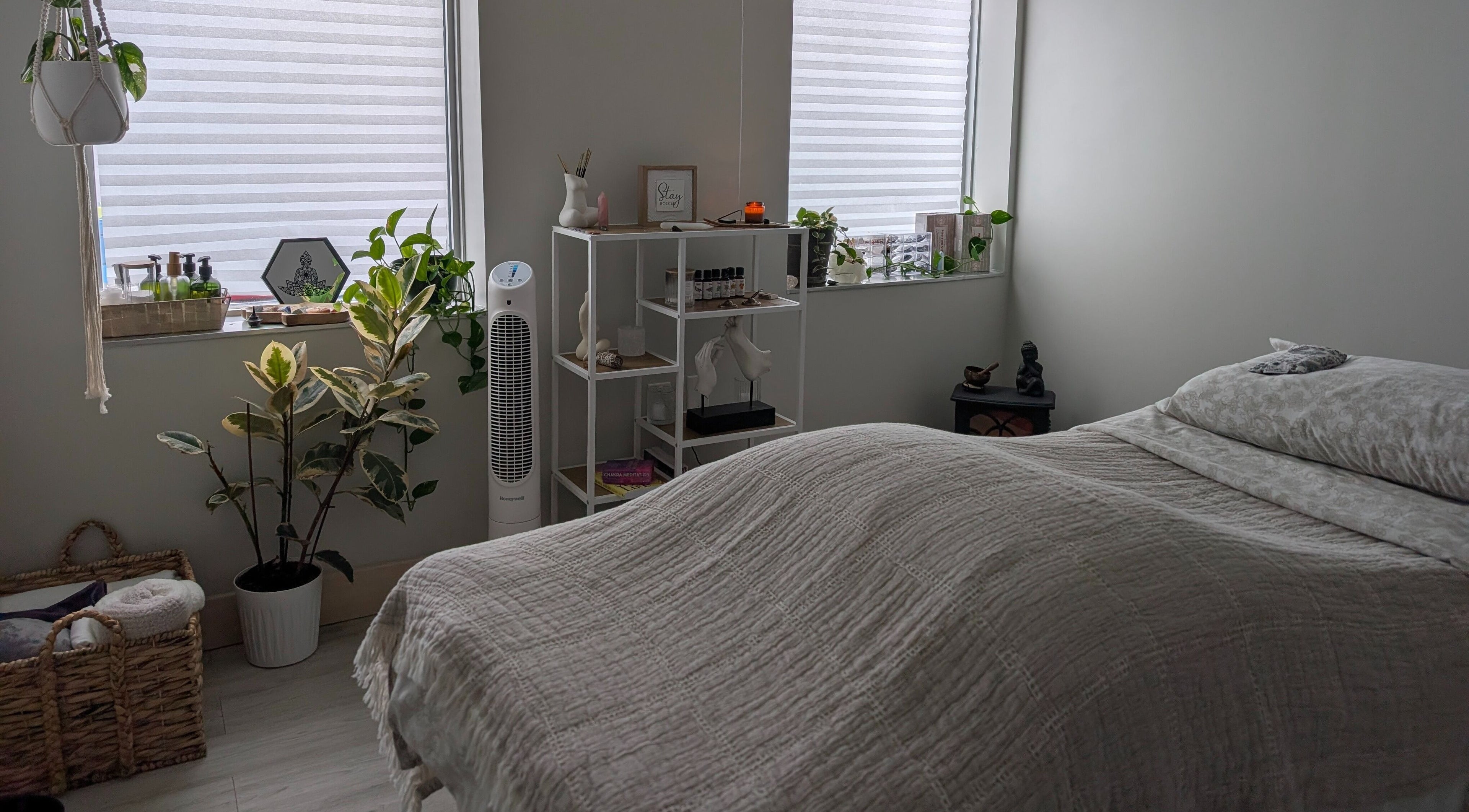 Tranquil massage room at The Celestial Root in Belleville, Ontario, CA with cozy bed and serene decor.