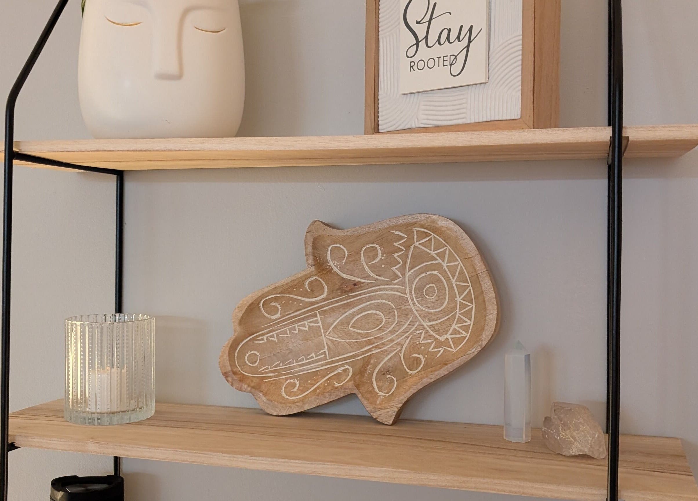 Decorative shelf at The Celestial Root, Belleville, Ontario, CA featuring art, candle, and crystals.
