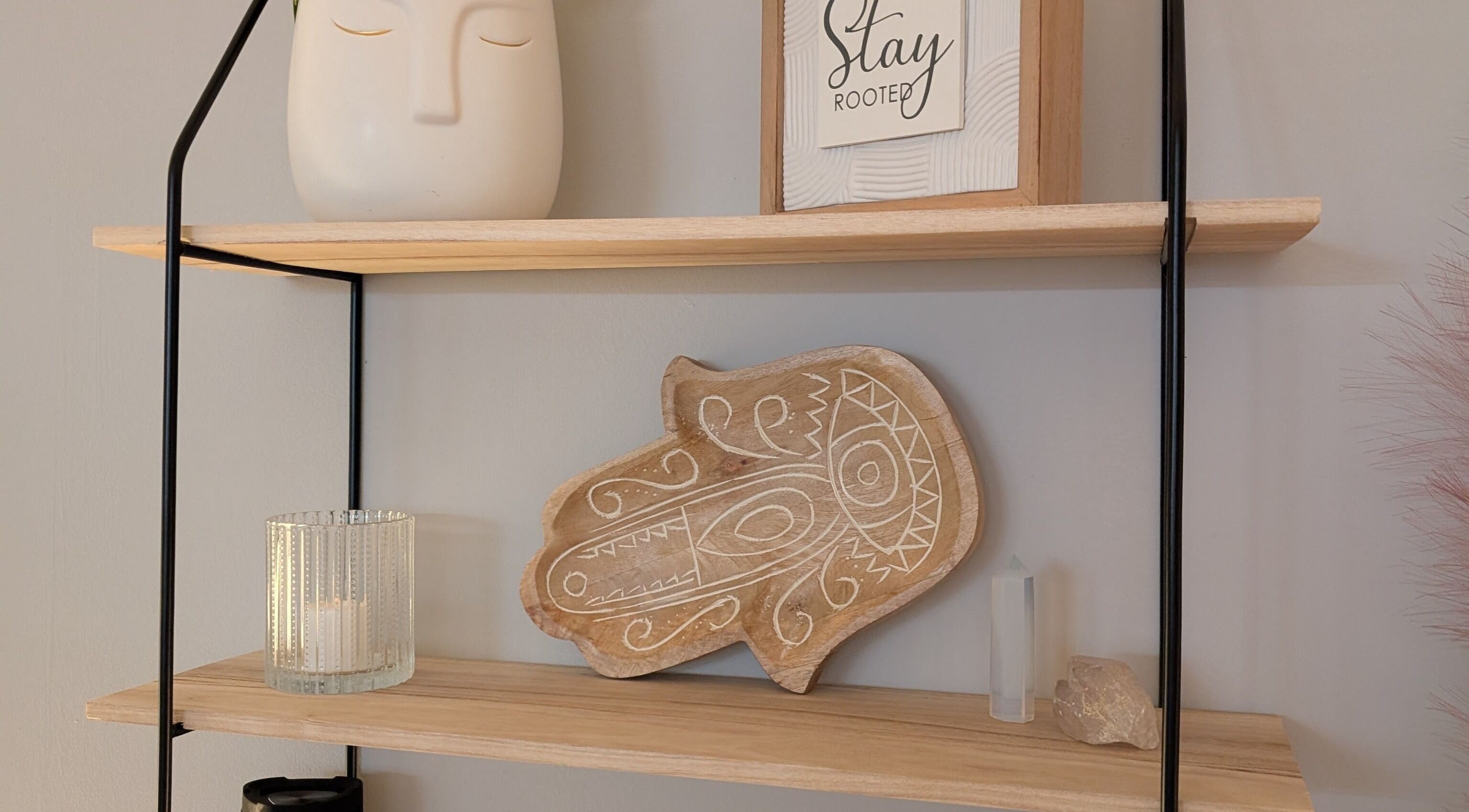 Decorative shelf at The Celestial Root, Belleville, Ontario, CA featuring art, candle, and crystals.