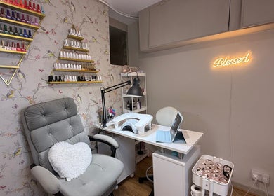 Mai Nails and Lash Studio's stylish nail station in London, England, GB with polish display and cozy chair.