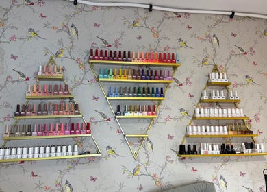 Triangular shelves with colorful nail polish at Mai Nails and Lash Studio, London, England, GB.