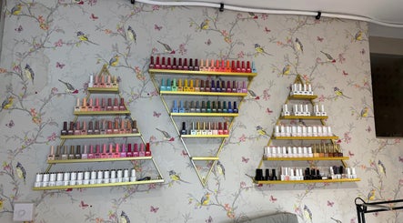 Triangular shelves with colorful nail polish at Mai Nails and Lash Studio, London, England, GB.