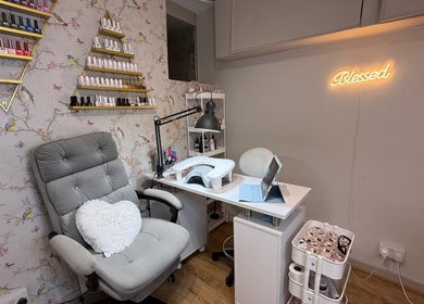 Cozy interior of Mai Nails and Lash Studio in London, England, GB, featuring nail polish displays and a plush chair.