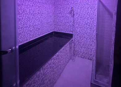 Lavender-lit spa room at Glowing Gents Salon and Spa, دبي, دبي, AE, featuring a tiled bath area.