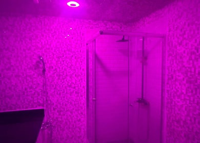 Chic shower stall with ambient pink lighting at Glowing Gents Salon and Spa, دبي, دبي, AE.