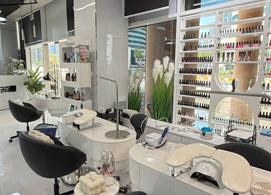 Modern interior of L'Art de Coiffure Salon in Dubai, AE, featuring elegant styling stations and product displays.
